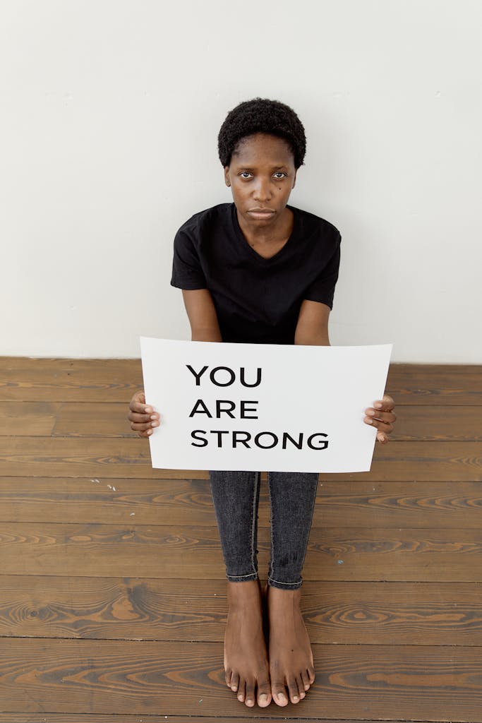 A person holding a 'You Are Strong' sign, symbolizing strength and empowerment.