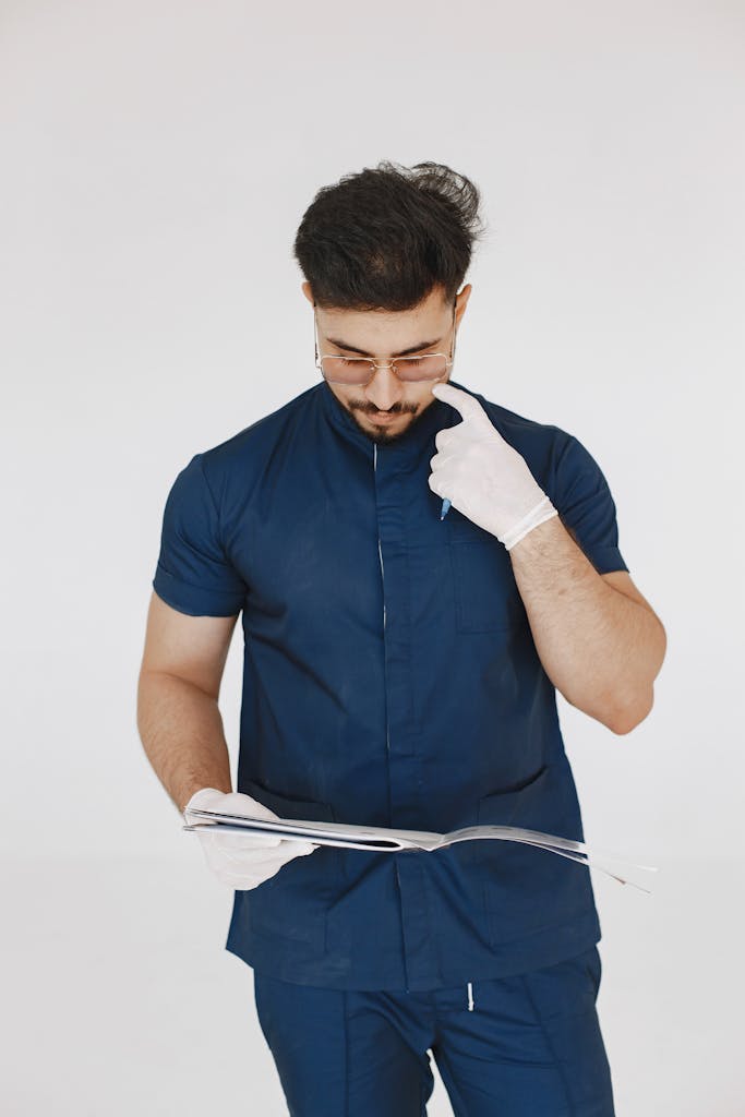 Portrait of a focused medical professional in scrubs reading documents indoors.